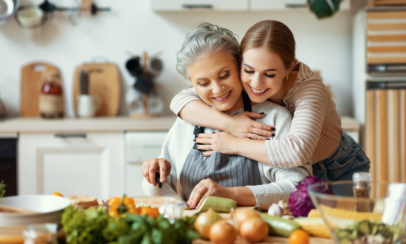 Mother and adult daughter preparing healthy foods