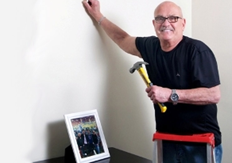 Kenneth hanging a photo