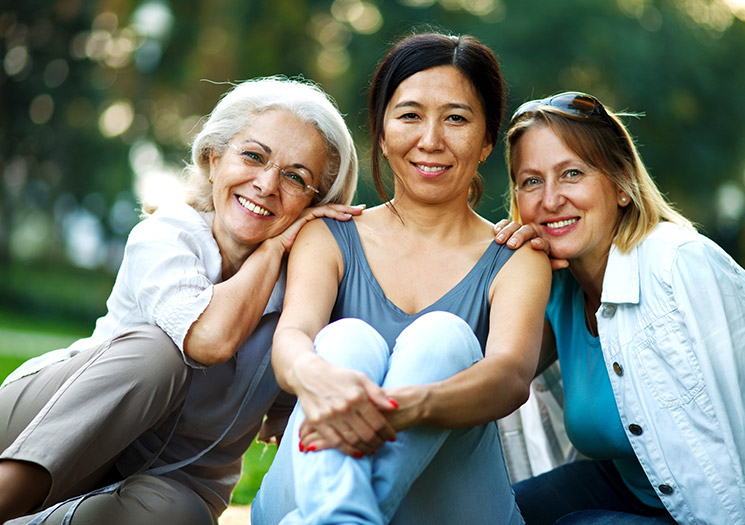 Three women sitting together outside